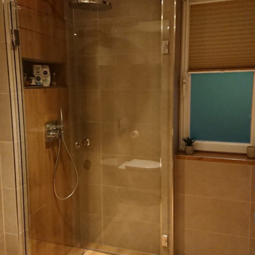Dusche eines modernen Badezimmers in Holzoptik in Lokstedt nach der Badsanierung durch Bäder Dunkelmann.