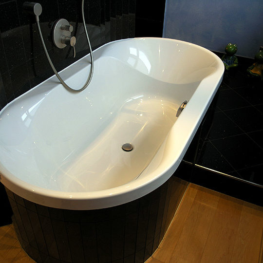 Abgerundete Badewanne in einem Granit Blue Pearl Badezimmer.