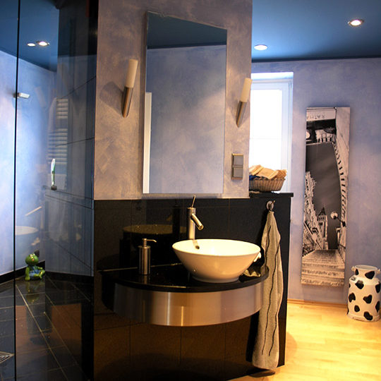 Freistehendes Keramik-Waschbecken in einem Granit Blue Pearl Badezimmer.