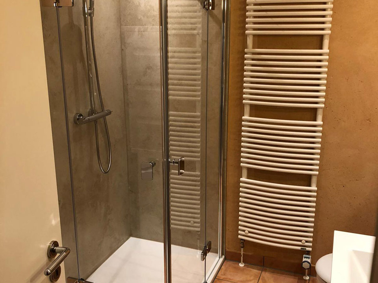 Badezimmer nach Renovierung: Duschbereich mit Glastüren