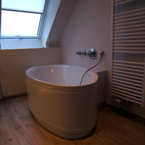 Badezimmer im Dachgeschoss mit freistehender Badewanne