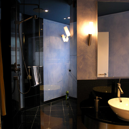 Elegante Glas-Duschlösung in einem Granit Blue Pearl Badezimmer.