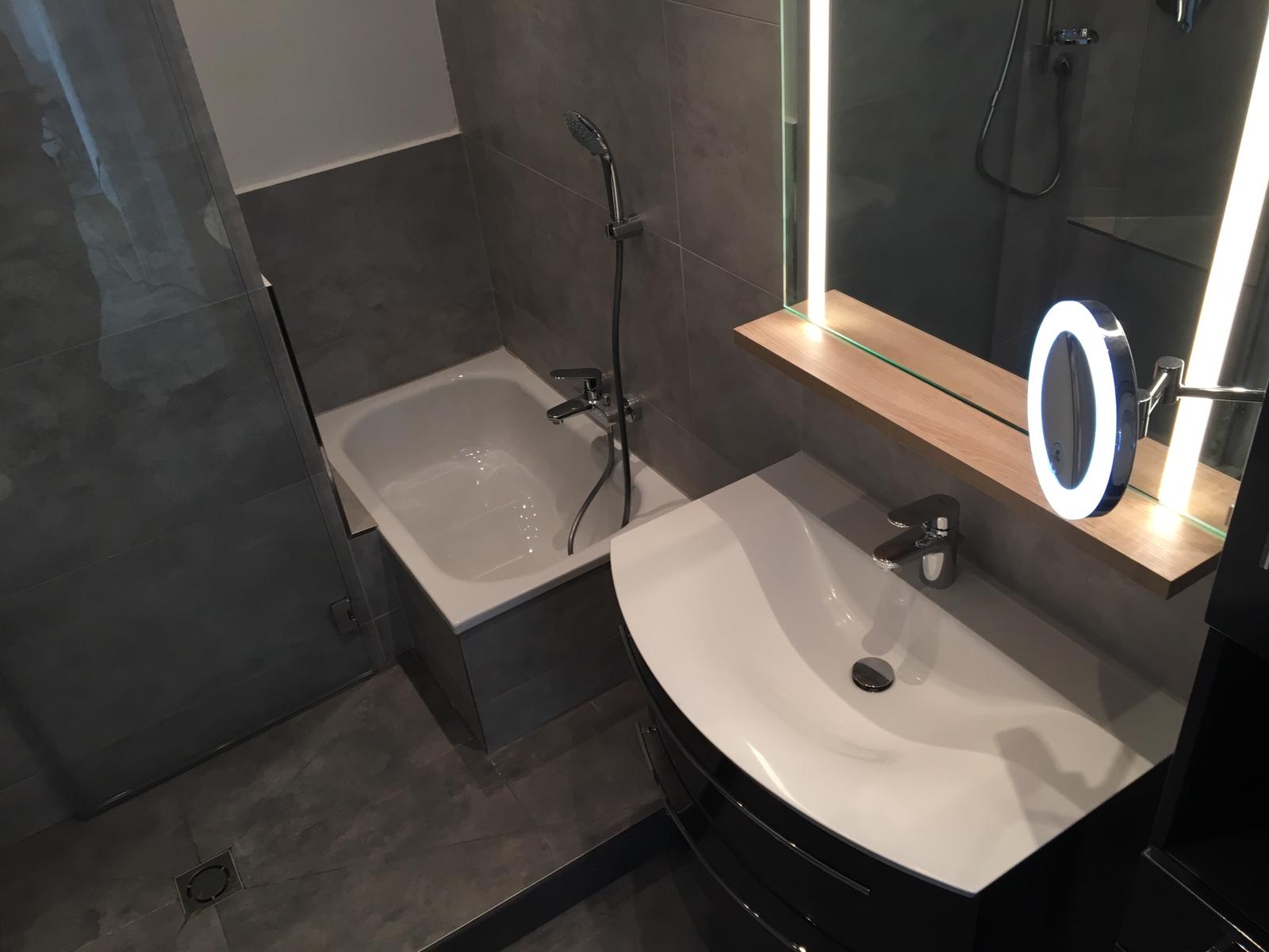 Kleines Badezimmer mit Waschtisch und Mini-Badewanne.